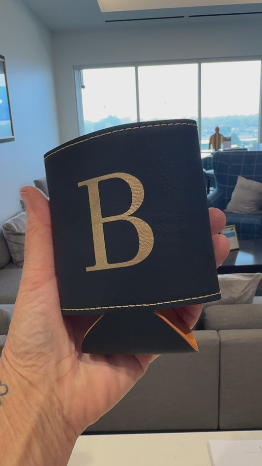 Personalized black leatherette can beverage holder with engraved gold initial at live event